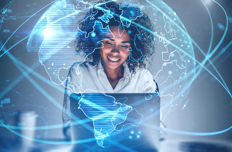 Cheerful,Young,African,American,Woman,Using,Laptop,In,Blurry,Office